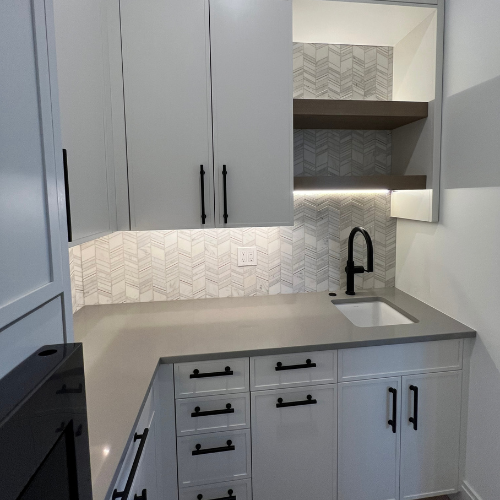 showroom corner kitchen with grey countertops, and sink